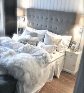 gray and white bed set with many pillows and fluffy comforter